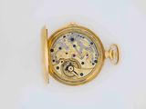 a close up of a gold pocket watch on a white surface