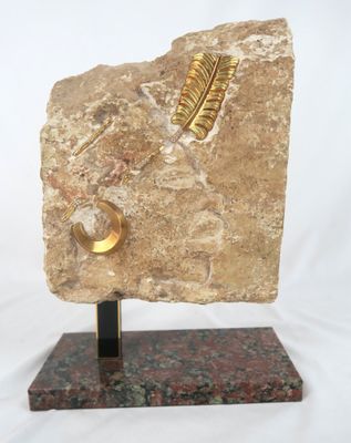 sculpture représentant une plume posée sur un rocher, reposant sur un socle en marbre