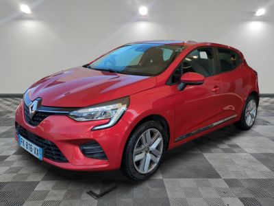une voiture rouge garée dans un garage au sol en damier