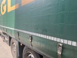 un gros camion vert garé sur le bord de la route