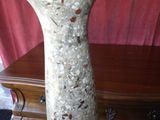 un vase posé sur une table devant un rideau rouge