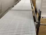 une image représentant un tapis roulant dans une usine, avec un tapis roulant au premier plan