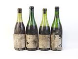 trois bouteilles de vin posées les unes à côté des autres sur une surface blanche