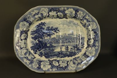 une assiette bleue et blanche sur laquelle est représentée une ville