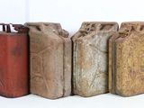 several old metal cans are lined up on a white surface