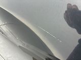 a close up of a person ' s hand on the hood of a car
