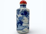 a small blue and white bottle with a red lid