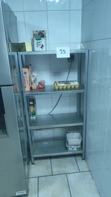 a silver refrigerator and a metal shelf in a kitchen
