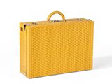 La valise jaune est posée sur une surface blanche.