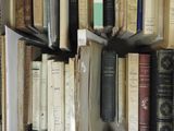 many books that are stacked on a shelf next to each other