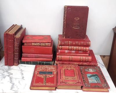 beaucoup de vieux livres posés sur une table à côté d'une horloge