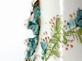 a vase with a bird painted on it sitting on a table