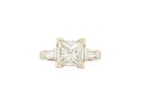 a princess cut diamond ring with baguets set in yellow gold
