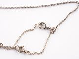 a close up of a silver chain with a silver bead on it