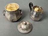 two silver teapots sitting next to each other on a table