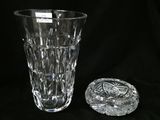 a glass vase and a glass ashtray on a black background