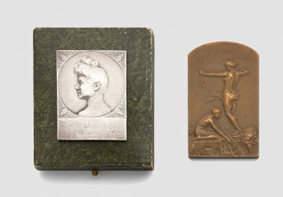an old book with a bronze plaque of a man on a cross and a bronze plaque of a man on a cross