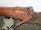 a brown leather case sitting on top of a green bag