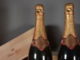 two bottles of champagne sitting on a table next to a wooden box