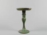 une petite table verte surmontée d'un piédestal