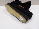 pair of black sued slippers on a white surface