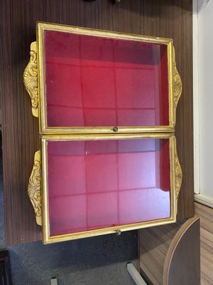 une vitrine rouge et dorée dans un coin de la pièce