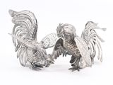 pair of silver rooster figurines on white background with white background