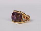 an image of a gold ring with a purple stone in it