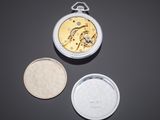 two silver and gold pocket watches sitting on top of a black surface