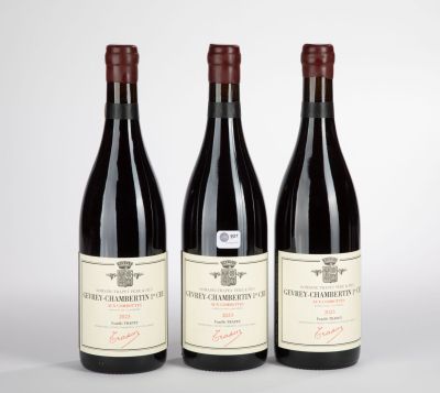 three bottles of red wine sitting next to each other on a table