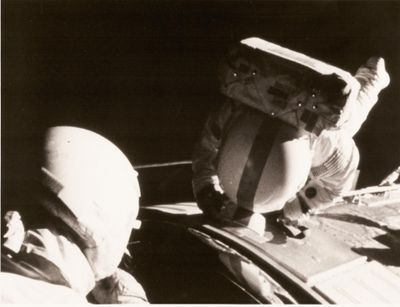 un homme assis à l'arrière d'une voiture, avec une boîte sur la tête