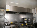 une grande cuisine en inox équipée d'une cuisinière et d'un four