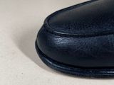 a close up of a pair of black shoes on a white surface
