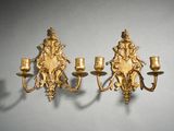 une paire d'appliques murales dorées, ornées chacune d'un cherensil