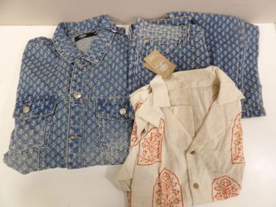 two pairs of blue and white shirts on display on a table