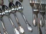 a lot of silver spoons and forks on the table