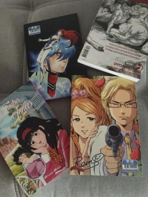 a lot of anime books sitting on a couch