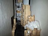 un couloir où se trouvent des cartons et d'autres objets par terre