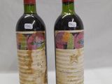 two bottles of wine sitting next to each other on a table