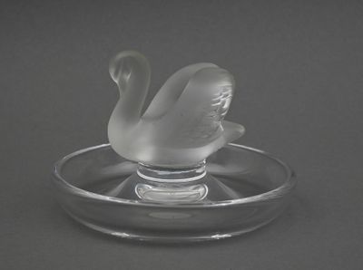 un cygne en verre posé sur une assiette en verre
