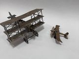une petite maquette d'avion et une autre petite maquette d'avion posées sur une surface blanche