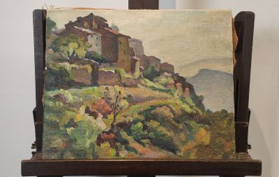 un tableau posé sur un chevalet, avec en arrière-plan un tableau représentant un village