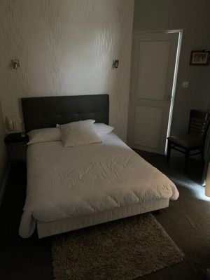 un lit blanc dans une petite chambre avec une fenêtre