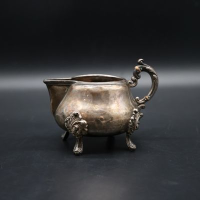 an antique silver plated bowl with handles and handles on a black surface