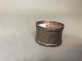 un porte-serviettes ancien plaqué argent posé sur une surface blanche