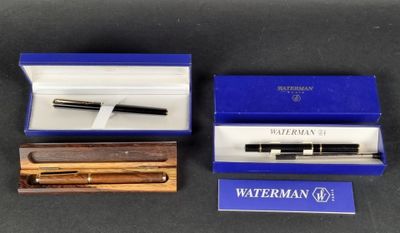 deux stylos à plume dans une boîte bleue et un stylo dans une boîte en bois