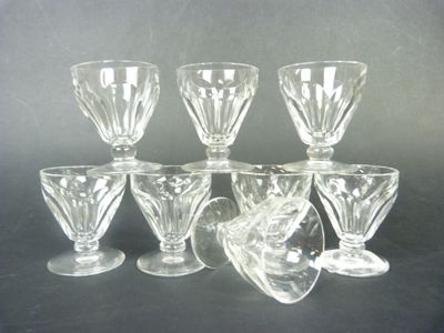 six clear glass goblets sitting on top of a black table