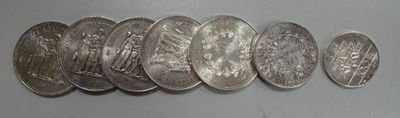 six quarters of silver coins are arranged in a row on a white surface