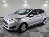 une Ford Fiesta argentée garée sur un sol à damier dans un garage