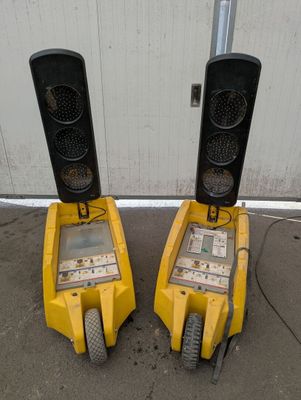 two yellow traffic lights sitting next to each other in front of a building